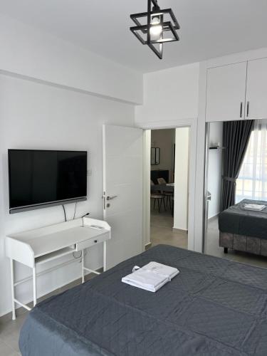 a bedroom with a bed with a desk and a television at Caesar Resort Didious in Iskele