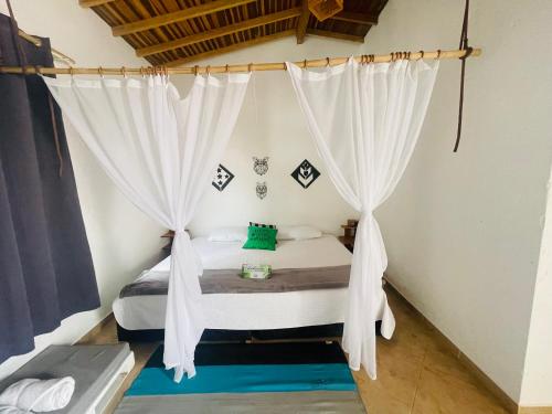 a bedroom with a bed with white curtains at Entre Verdes Hotel & Glamping in Medellín