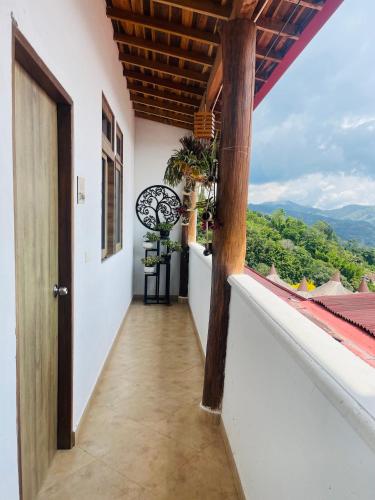 a corridor of a house with a balcony with a view at Entre Verdes Hotel & Glamping in Medellín