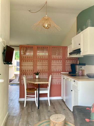 une cuisine avec une table et des chaises dans une pièce dans l'établissement Studio indépendant calme et climatisé en campagne, au Thor