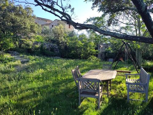 a table and chairs in the grass in a yard at Gîtes du Mas Champion - Piscine, Soleil, Nature & Calme - groupes in Saint-Just-et-Vacquières