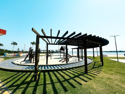 a playground in a park next to the beach at Apt de frente e com vista Lagoa in Arraial do Cabo