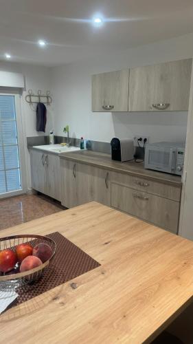- une cuisine avec un bol de fruits sur une table dans l'établissement Dom Nouvelle Vie, à Bergerac