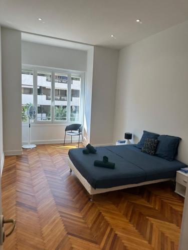 une chambre avec un grand lit et un parquet dans l'établissement Golden House Cannes, à Cannes