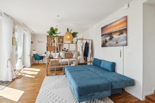 a living room with a blue couch in the middle of it at Business I Family Apartment I 1-4 Personen - Aare Blick, nahe Altstadt I Beamer - 99" Leinwand I Terrassen Lounge und Parkplatz in Brugg