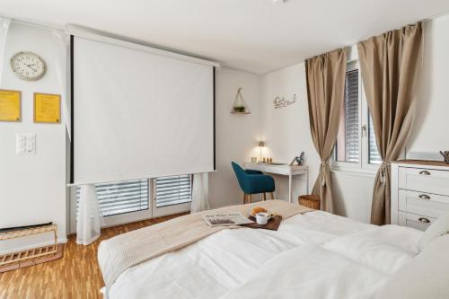a white bedroom with a bed and a desk at Business I Family Apartment I 1-4 Personen - Aare Blick, nahe Altstadt I Beamer - 99" Leinwand I Terrassen Lounge und Parkplatz in Brugg