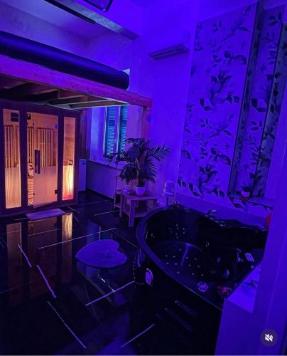 a purple room with a bath tub and a table at Lovers in Fiuggi in Fiuggi