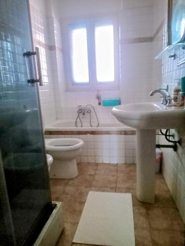 a bathroom with a sink and a toilet and a tub at Adelia House in Catania