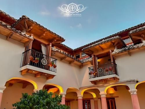 a building with two balconies with flowers on them at Hotel Casa de Familia de San Cristobal in San Cristóbal de Las Casas