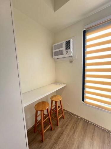 a small room with two stools and a microwave at CebuSureStay - The Median Cebu in Tabok