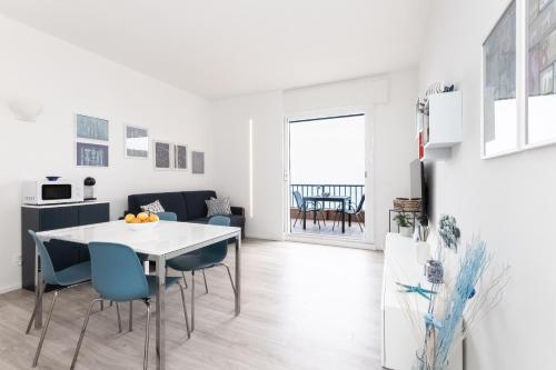 a kitchen and dining room with a white table and blue chairs at -Terrazza Sul Mare- & Parcheggio Privato in Varazze