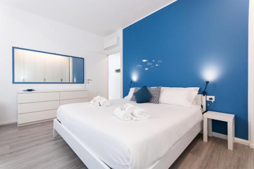 a bedroom with a large white bed with a blue wall at -Terrazza Sul Mare- & Parcheggio Privato in Varazze