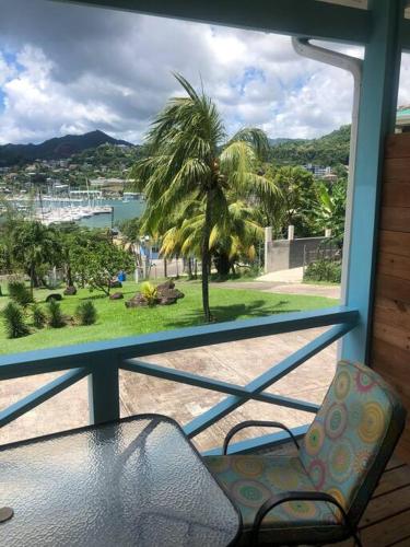 a view of a palm tree from a window at CasaCalypso Grenada in Belmont