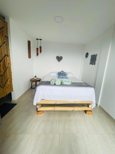 a bedroom with a bed in a white room at Entre Verdes Hotel & Glamping in Medellín