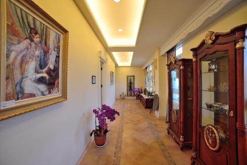 鹿谷的住宿－維多麗亞玫瑰莊園，墙上挂着一幅画的走廊和花瓶