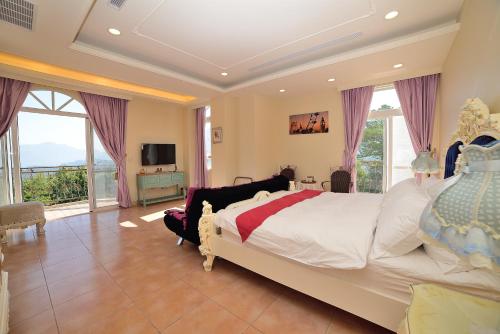 鹿谷的住宿－維多麗亞玫瑰莊園，一间带大床的卧室和一个阳台