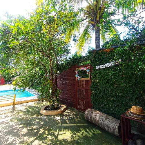 a sign for a hotel with a tree next to a pool at Paraiso Hortensia Ecolodge in Santiago de los Caballeros