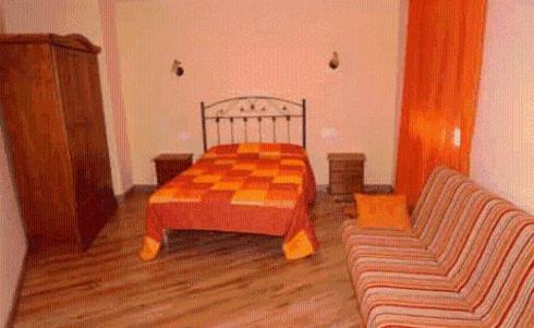 een slaapkamer met een geruit bed en een bank bij Alojamiento rural la Bellosina in Cabezabellosa
