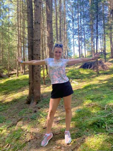 a woman standing in the woods with her arms out at Мелодія Гір Вид на гори in Vorokhta