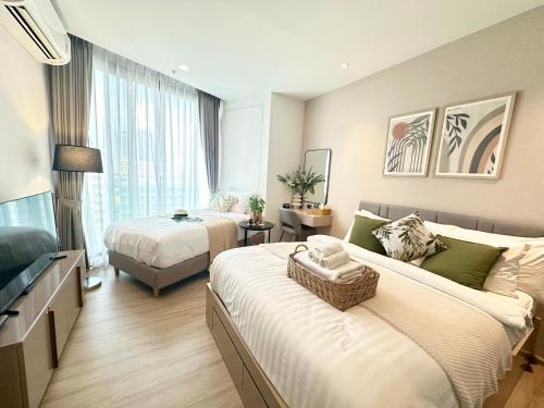 a hotel room with two beds and a couch at EDGE Cozy Vacation Condo infinite SKY Pool in Pattaya Central