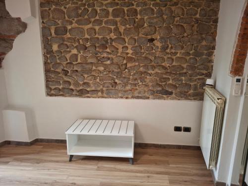 a white bench sitting in front of a brick wall at Il Micco in Pistoia