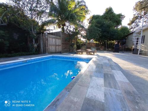 a swimming pool with blue water in a yard at Paraiso Hortensia Ecolodge in Santiago de los Caballeros