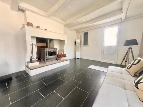 a living room with a fireplace and a couch at REFUGE CHAMPETRE - Moderne & Confort - Jardin Terrasse Barbecue - Parking et Wifi Gratuit - ESPACE ET DETENTE - Parfaitement équipé - Idéal FAMILLE in Saint-Coutant-le-Grand