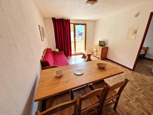 une salle à manger avec une table et des chaises en bois dans l'établissement Résidence Le Cheval Blanc - 3 pièces 6 personnes 37 m² MAE-2935, à Modane