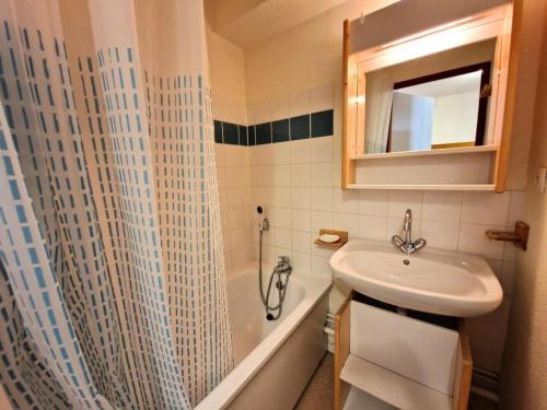 une salle de bain avec un lavabo et un rideau de douche dans l'établissement Résidence Le Cheval Blanc - 3 pièces 6 personnes 37 m² MAE-2935, à Modane