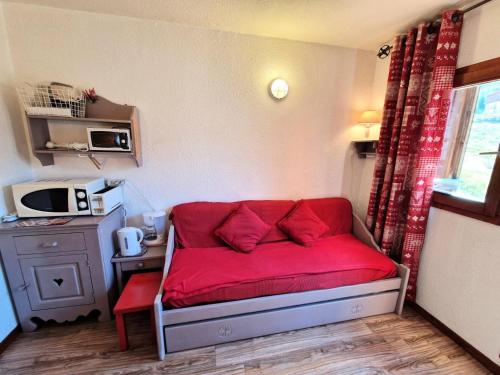 - un canapé avec des oreillers rouges dans l'établissement Chalet Club - Studio 2/3 personnes 17 m² MAE-2988, à Modane