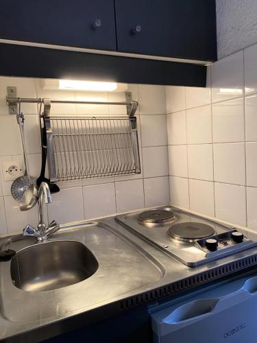 une cuisine avec un évier et une cuisinière dans l'établissement Chalet Club - Studio 17 m² MAE-2985, à Modane