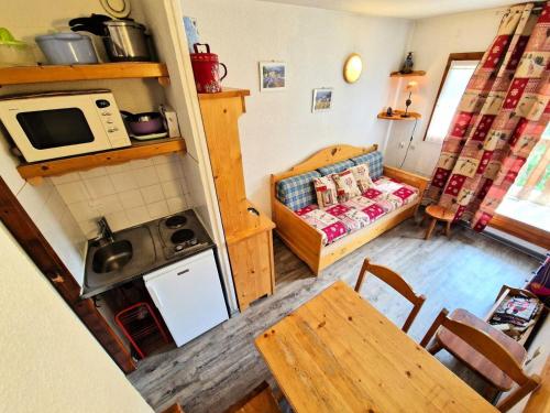 une cuisine et un salon avec une table et un canapé dans l'établissement Chalet Club - Studio 2/3personnes 17 m² MAE-2995, à Modane