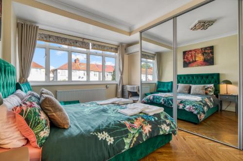 Un dormitorio con dos camas y un espejo. en Casa Marina- 4 bedroom house with garden and balcony, en Golders Green