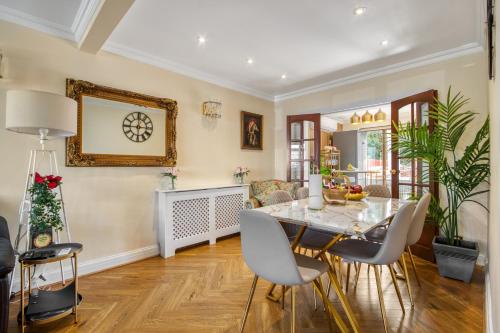 a dining room with a table and chairs at Casa Marina- 4 bedroom house with garden and balcony in Golders Green