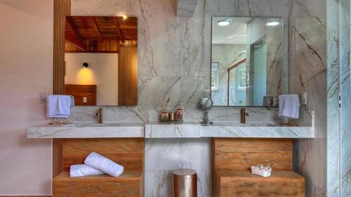a bathroom with a sink and a mirror at Monte Verde Lofts Araucária in Monte Verde