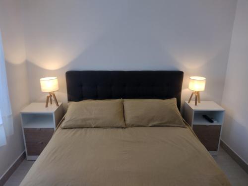 a bedroom with a bed with two nightstands and two lamps at Precioso departamento en Paraná. Zona Centro in Paraná