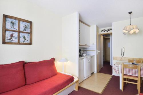 un salon avec un canapé rouge et une cuisine dans l'établissement Résidence Callisto - Studio pour 4 Personnes 11, à Mâcot La Plagne