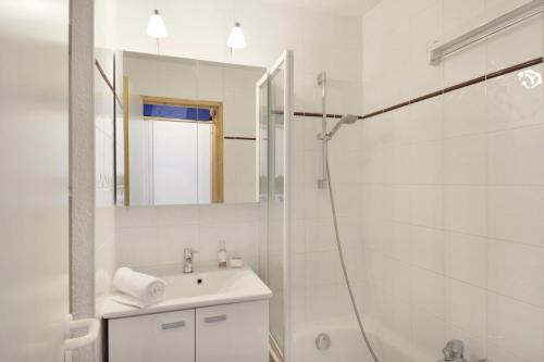 une salle de bain blanche avec une douche et un lavabo dans l'établissement Résidence Callisto - Studio pour 4 Personnes 11, à Mâcot La Plagne