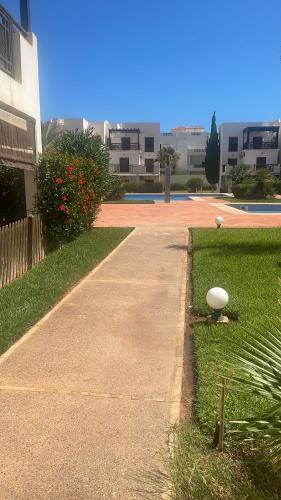 a walkway in front of a building with a yard at Ap 7 imm in Cherarba