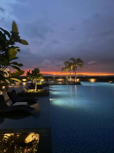a view of a pool at a resort at night at Stylish 1BR Near Airport Facing the Bay - 7b in Manila