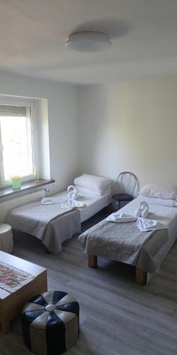 a room with two beds and a window at Ночлеги - HOSTEL in Tarnowo Podgórne