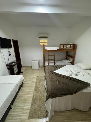 a room with two beds and a desk in it at Villa Brilho do Sol Jeri in Jericoacoara
