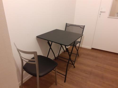 - une table noire et une chaise dans la chambre dans l'établissement studio coeur de ville, à La Flèche
