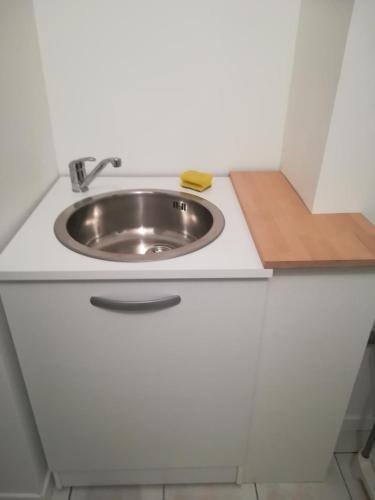 La salle de bains est pourvue d'un lavabo dans une armoire blanche. dans l'établissement studio coeur de ville, à La Flèche