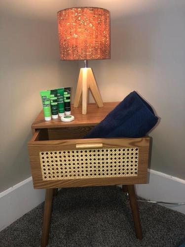 a nightstand with a lamp and a blue pillow on it at Eco Friendly Home by Cincy w Office Space in Dayton
