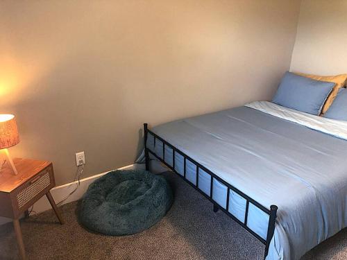 a bedroom with a bed and a ottoman next to a lamp at Eco Friendly Home by Cincy w Office Space in Dayton
