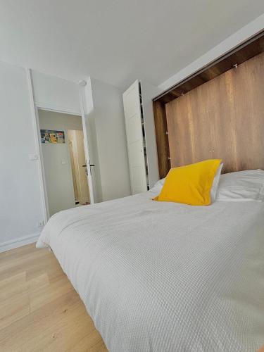 une chambre avec un grand lit avec un oreiller jaune dans l'établissement le Petit Pénitent Quartier Doré, à Marvejols