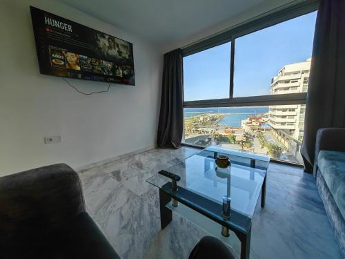 a living room with a glass table and a large window at City Bleu Maroc in Tangier