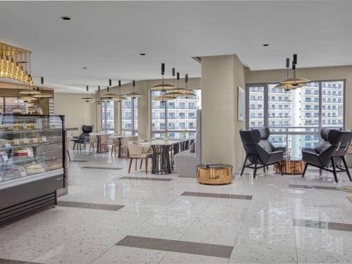 a lobby with chairs and tables in a building at Novotel Suites Manila Aqua Residences Near Makati by Hamodi'sCrib in Manila