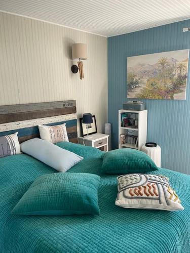 une chambre avec un grand lit avec des draps bleus dans l'établissement Au bord du ciel Magnifique appartement à Bandol, à Bandol
